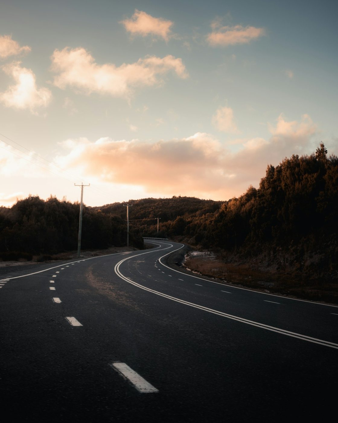 A curving road near Strahan beneath an evening sky