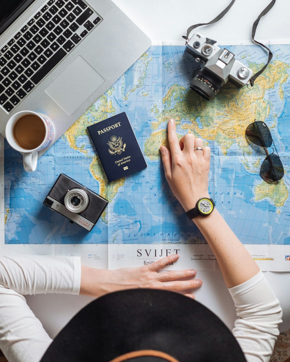 A traveller planning with a paper map, notebook and camera